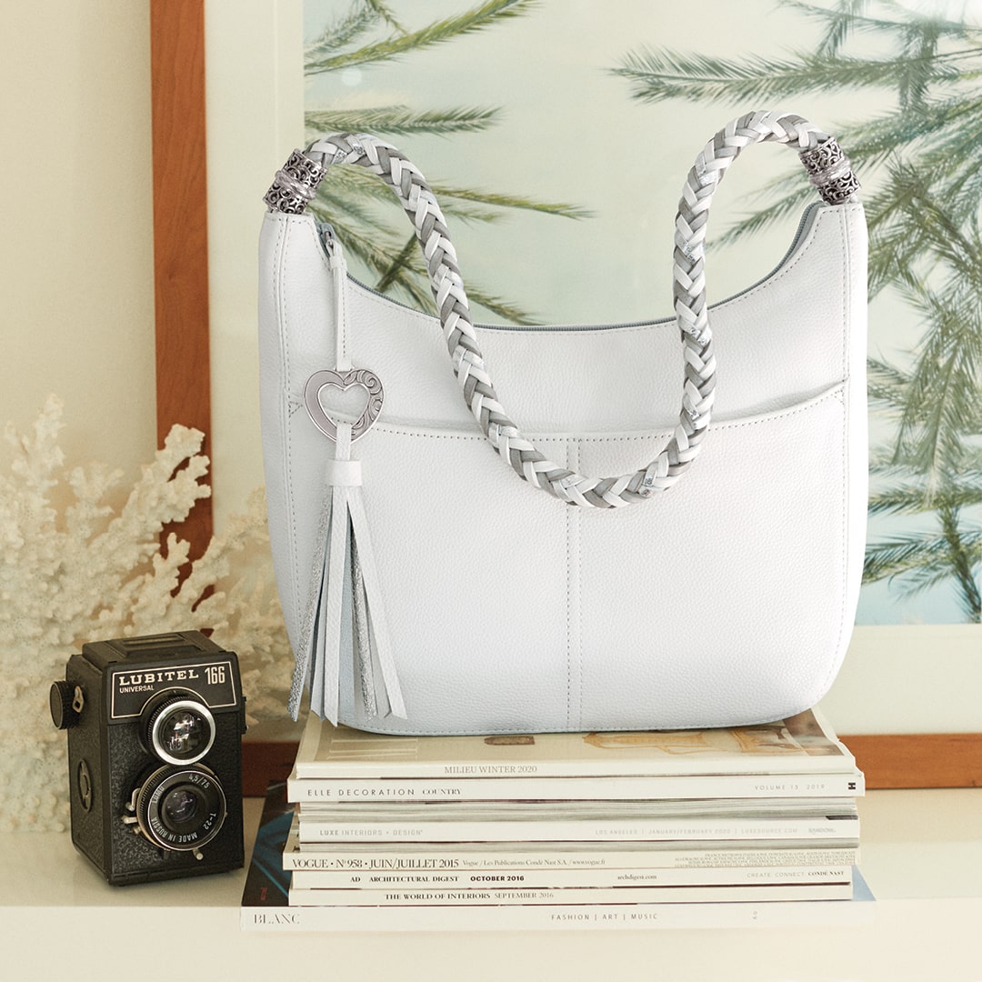 White handbag on a stack of magazines