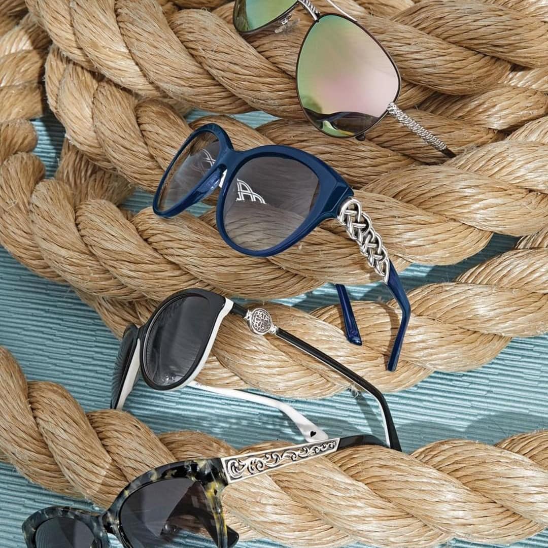 Multiple pairs of sunglasses on woven background