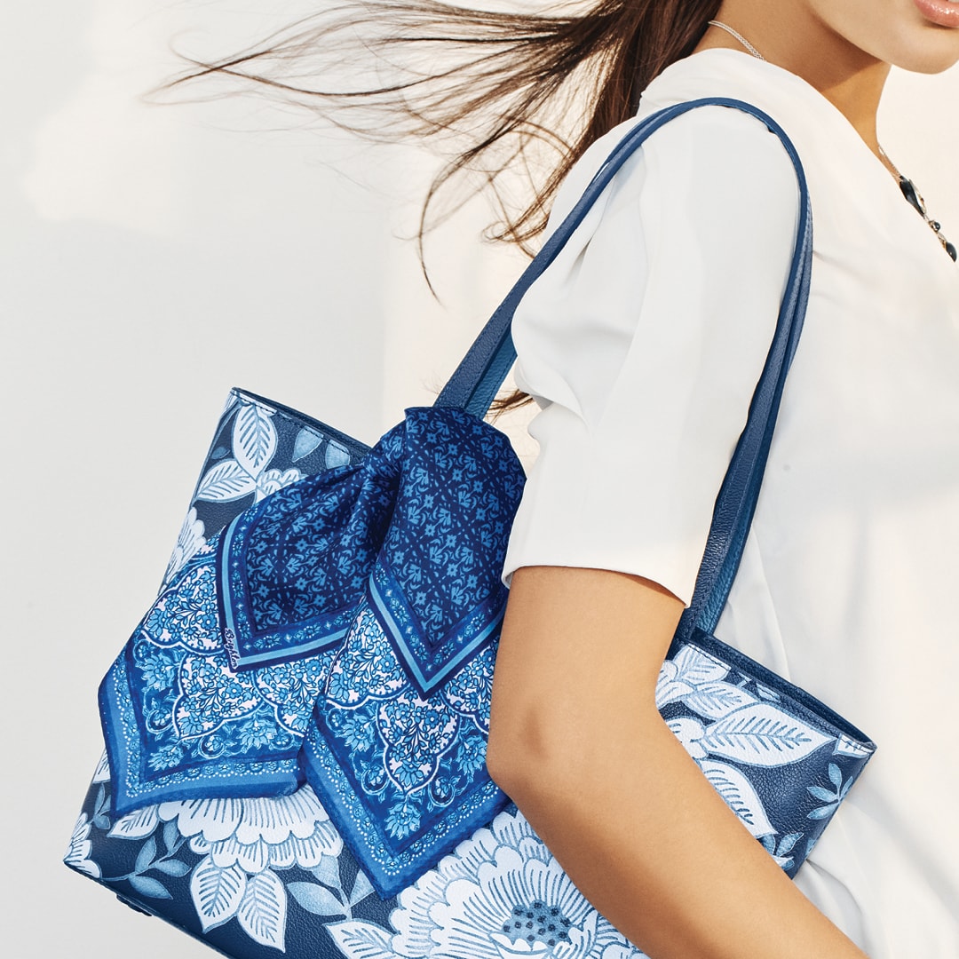 Model holding blue flower bag
